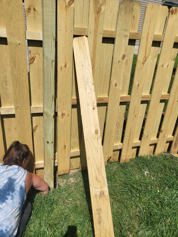 New wood privacy fence under construction in a backyard